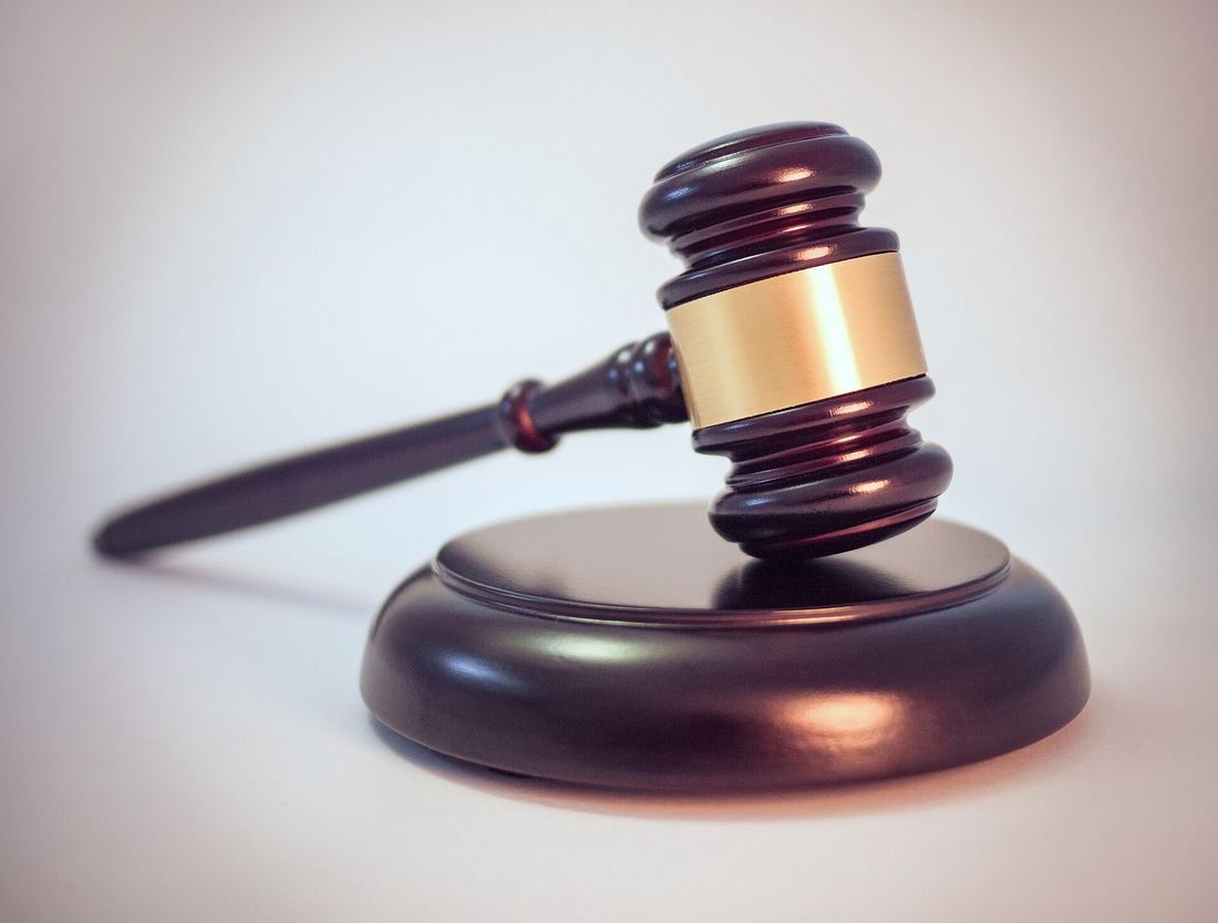 A wooden judge's gavel on its sound block